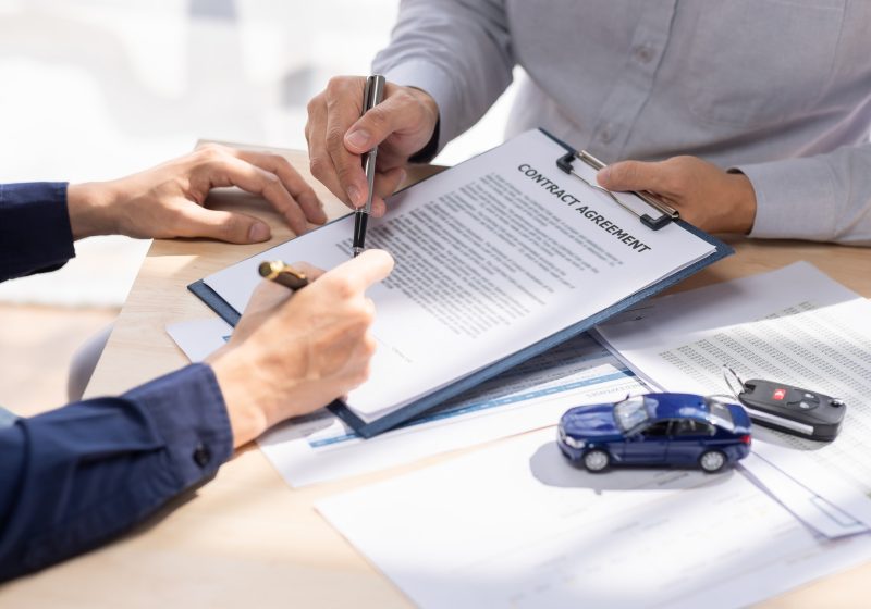Car Insurance document or lease concept the car broker assisting his customer and explaining the
