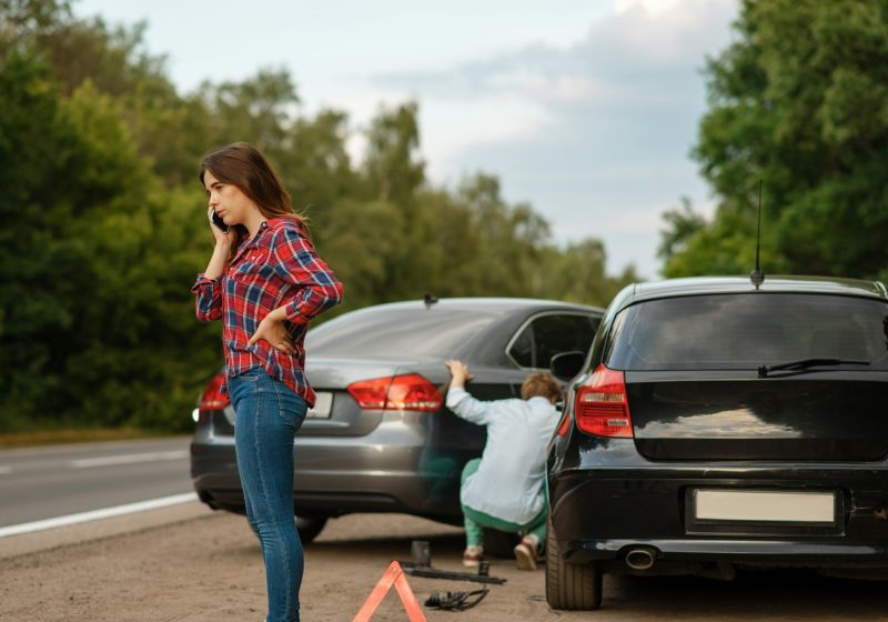 Male and female drivers on road, car accident