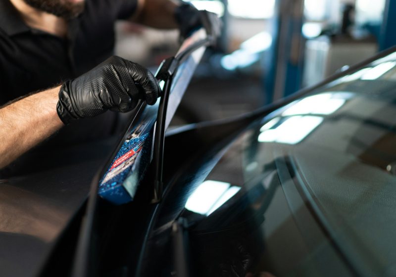 Service technician replaces windshield wipers of the car