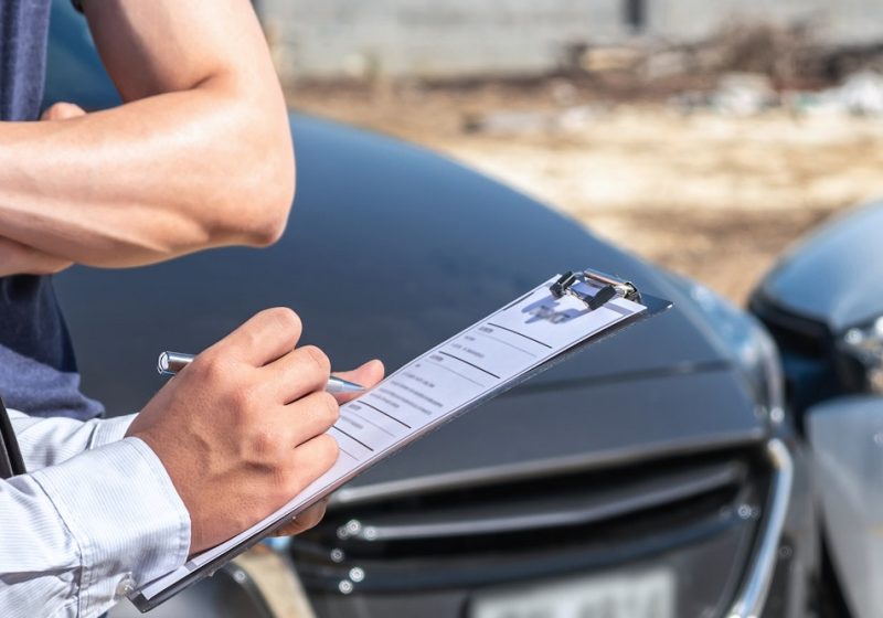 Insurance agent examine the damage of the car after accident on report claim form process